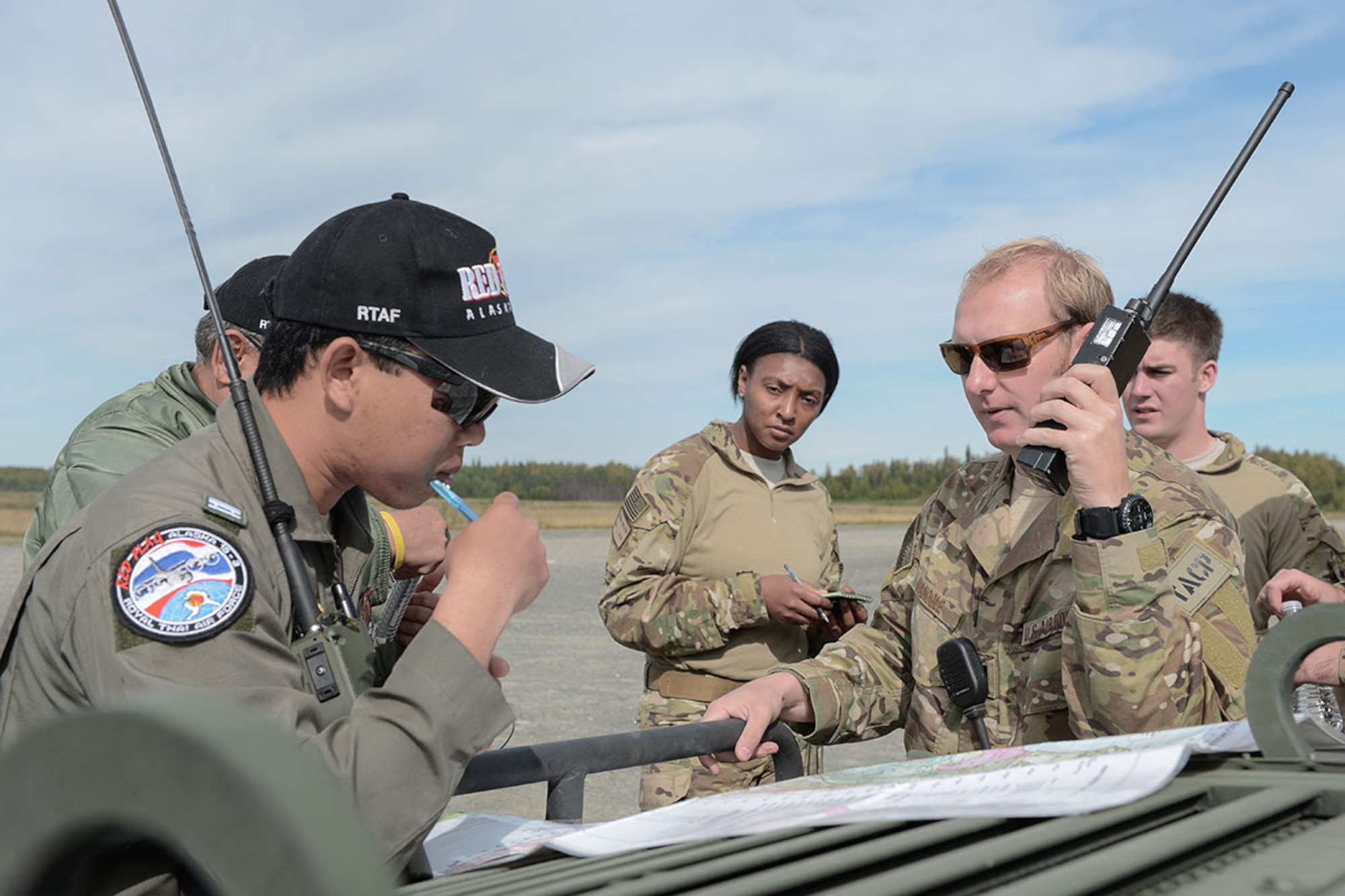 Flight Lieutenant Phongsakron Namjit, Royal Thai Air Force combat controller, and U.S. Air Force Capt. Michael Spanogle, 3rd Air Support Operations Squadron Air Mobility Liaison Officer, coordinate an airdrop during Red Flag Alaska 15-3. (U.S. Air Force photo/Staff Sgt. Cody Ramirez)
