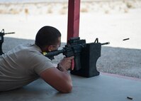A participant in the M4 rifle qualification course fires his M4 at the 99th Security Forces Squadron Combat Arms Training and Maintenance firing range on Nellis Air Force Base, Nev., Aug. 18, 2015. Airmen switched between using iron sights and red dot sights to qualify for the M4 as they prepare to deploy, make a permanent change of station move, or satisfy yearly training requirements. (U.S. Air Force photo by Airman 1st Class Jake Carter)
