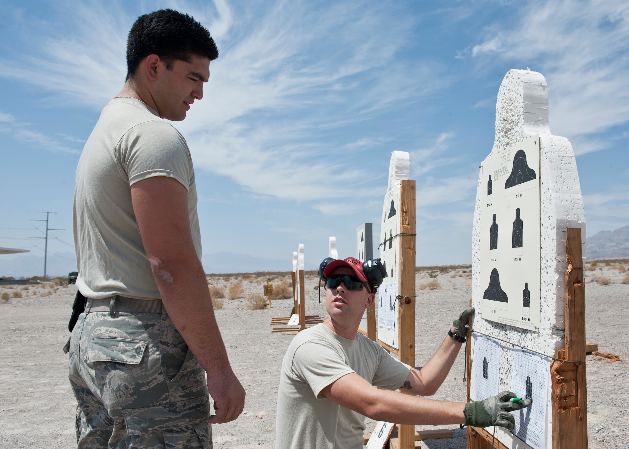 A combat arms instructor provides feedback to a participant in the M4 rifle qualification course at the 99th Security Forces Squadron Combat Arms Training and Maintenance firing range on Nellis Air Force Base, Nev., Aug. 18, 2015. To qualify for marksmanship, Airmen needed to hit 17 of 24 targets and to achieve expert, needed to hit 22 of 24. (U.S. Air Force photo by Airman 1st Class Jake Carter)