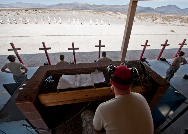 Staff Sgt. Justin Jones, 99th Security Forces Squadron combat arms instructor, gives commands to participants in a M4 rifle qualification at the 99th SFS Combat Arms Training and Maintenance firing range at Nellis Air Force Base, Nev., Aug. 18, 2015. CATM training curriculum is designed in a way that even someone who has never handled a weapon before in their life can become qualified after attending their course. (U.S. Air Force photo by Airman 1st Class Jake Carter)