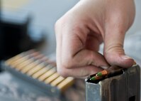 A participant in the M4 rifle qualification course loads ammunition into a cartridge at the 99th Security Forces Squadron Combat Arms Training and Maintenance firing range on Nellis Air Force Base, Nev., Aug. 18, 2015. Combat arms instructors with the 99th SFS provide training to over 15,000 individuals every year, making them one of the busiest CATM sections in Air Combat Command. (U.S. Air Force photo by Airman 1st Class Jake Carter)
