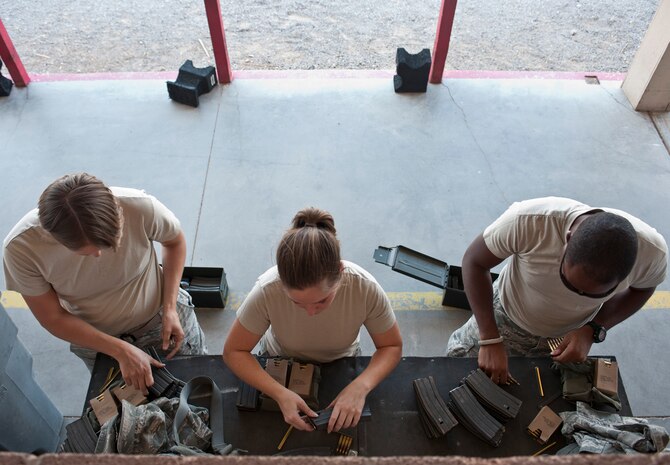 Participants in the M4 rifle qualification course load ammunition into their respective cartridges at the 99th Security Forces Squadron Combat Arms Training and Maintenance firing range on Nellis Air Force Base, Nev., Aug. 18, 2015. Airmen participated in the qualification course in preparation for either a deployment, permanent change of station move, or part of yearly training. (U.S. Air Force photo by Airman 1st Class Jake Carter)