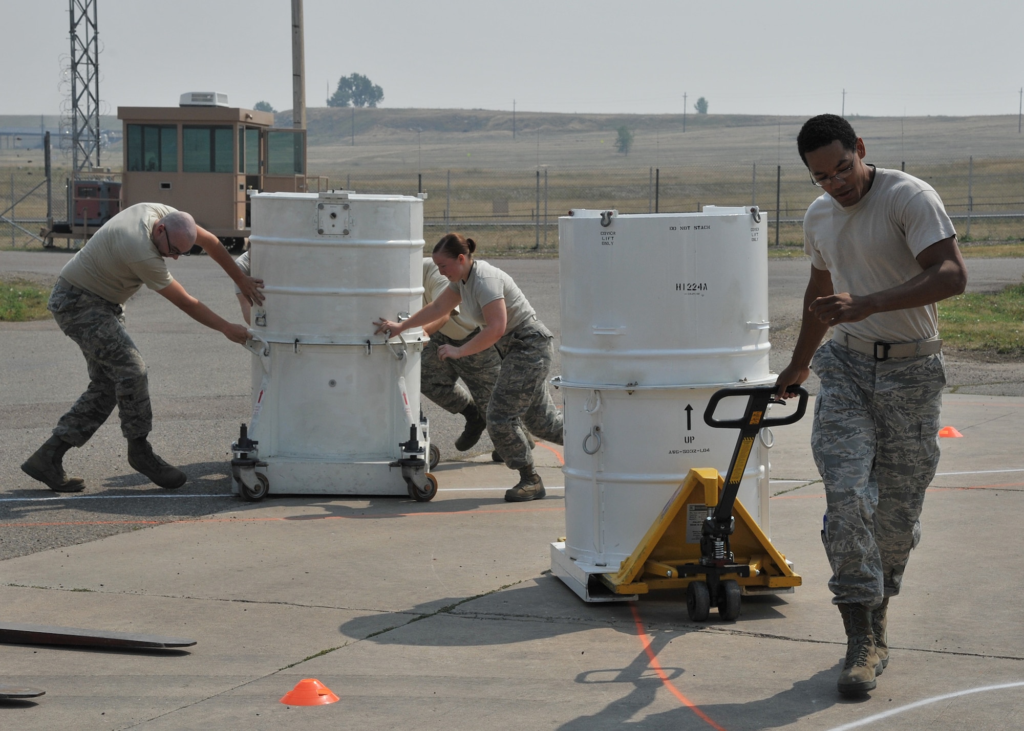 Staff Sgt. Sean Glenn, 341st Munitions Squadron, pulls an empty warhead storage container through a serpentine course Aug. 25, 2015, at the Malmstrom Air Force Base, Mont., weapons storage area as his Global Strike Challenge 2015 teammates push a second ‘can’ to the course finish line. The team was practicing for a ‘handling rodeo,’ a timed event in Air Force Global Strike Command’s ICBM maintenance competition and one of three events that the 341st Missile Wing’s GSC 2015 MUNS team will compete in Sept. 2-4. The results will be revealed in October and compared to similar teams from Minot AFB, N.D., and F.E. Warren AFB, Wyo. (U.S. Air Force photo/John Turner)