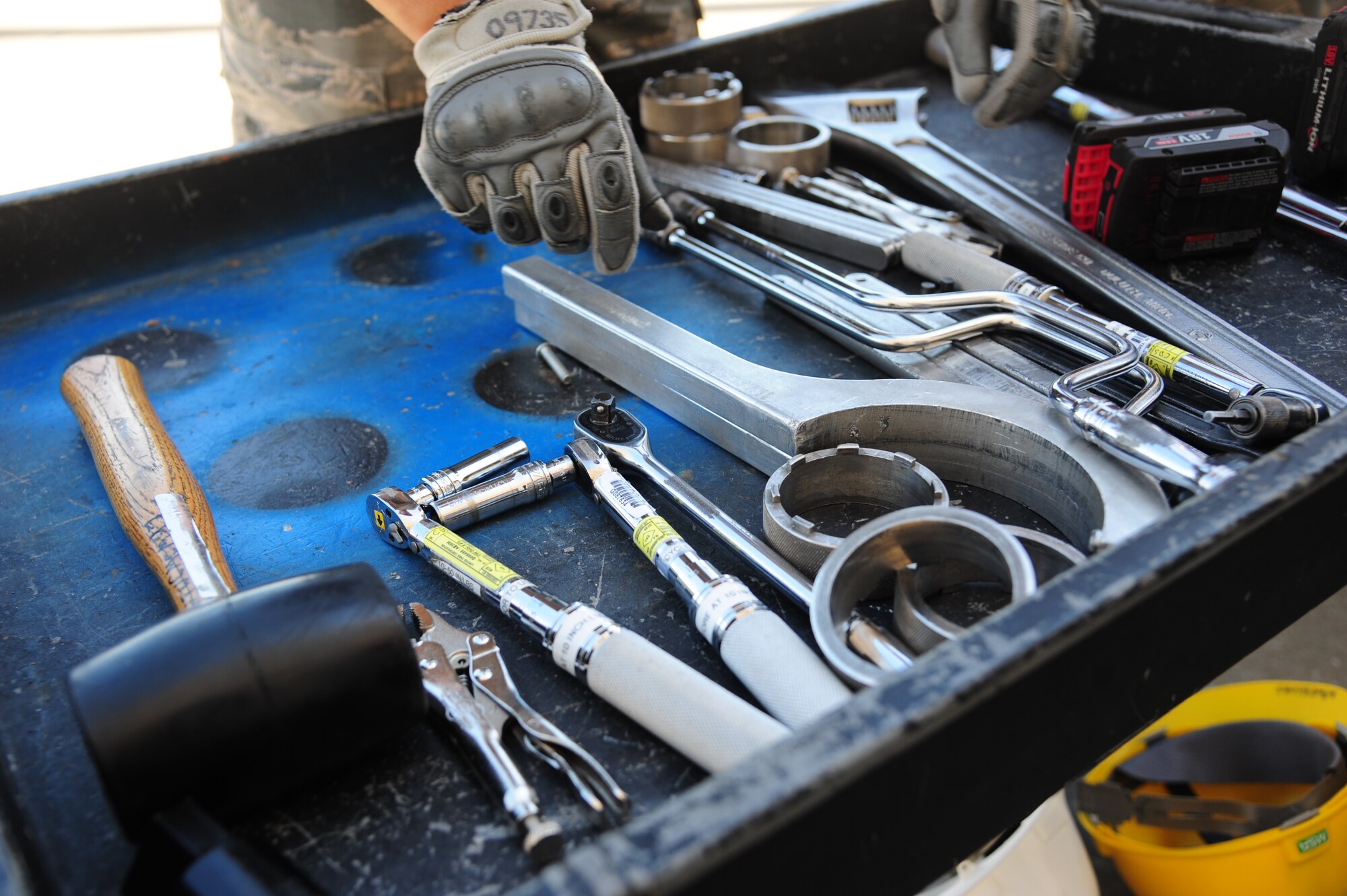 U.S. Air Force Airman 1st Class Kevin Hernandez-Vasquez, 509th Munitions Squadron conventional maintenance journeyman, reaches for tools at Whiteman Air Force Base, Mo., Aug. 11, 2015. Conventional load crews use 300 pieces, consisting of a wide range of components, and wide variety of utensils to consolidate this operation. (U.S. Air Force photo by Senior Airman Keenan Berry/Released)