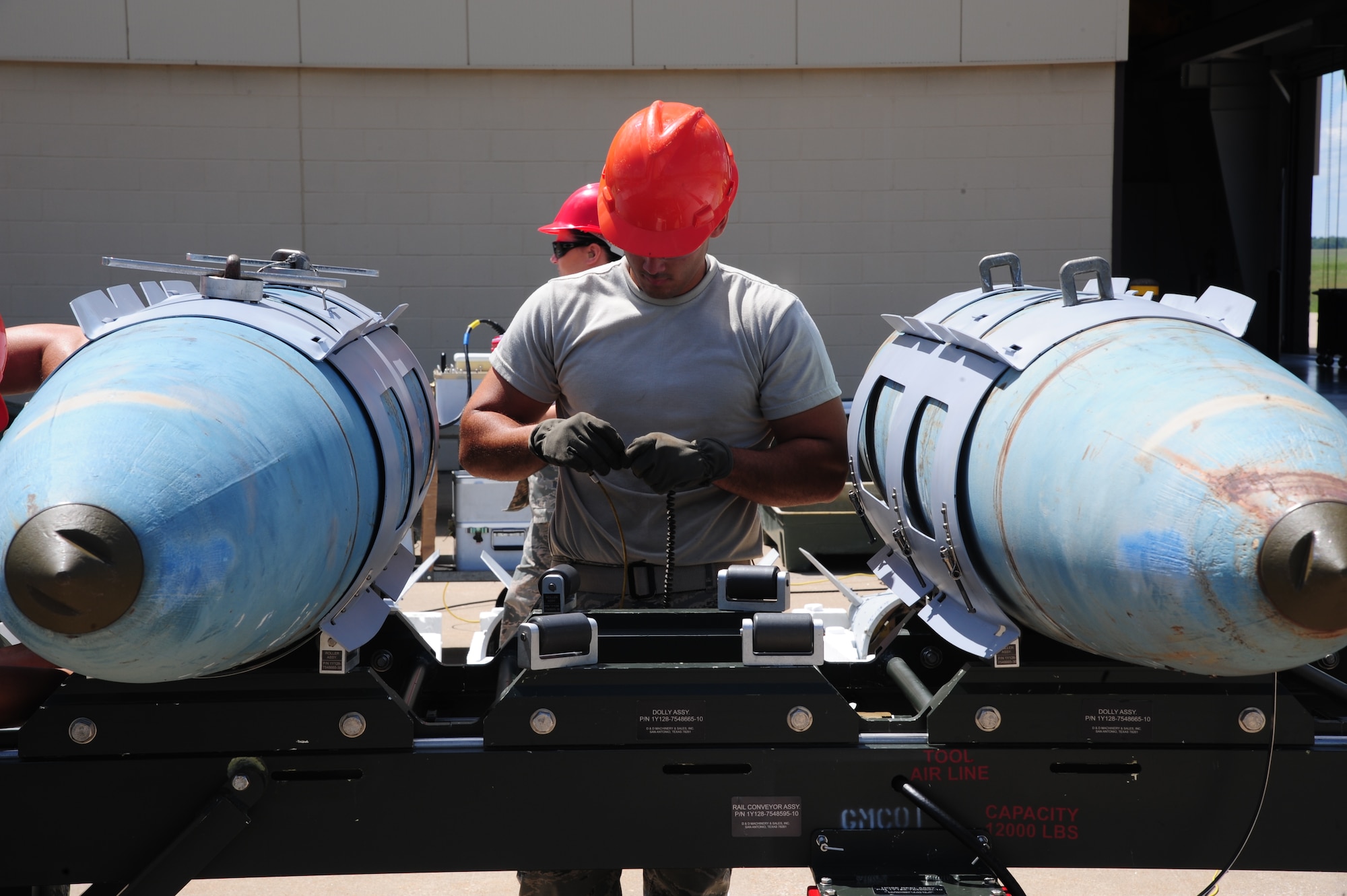 U.S. Air Force Airman 1st Class Kevin Hernandez-Vasquez, 509th Munitions Squadron conventional maintenance journeyman, prepares a power cable for a fuse at Whiteman Air Force Base, Mo., Aug. 11, 2015. This procedure is done to prepare for installation of a power cable into a MK-84 bomb body. (U.S. Air Force photo by Senior Airman Keenan Berry/Released)