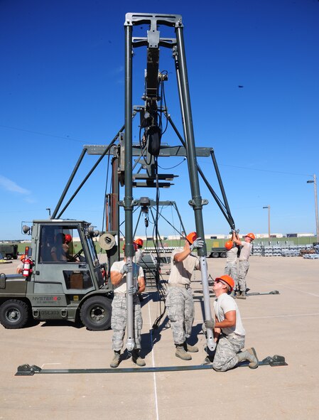 Members from the 509th Munitions Squadron prepare the gantry assembly on the Munitions Assembly Conveyor at Whiteman Air Force Base, Mo., Aug. 11, 2015. Conventional load crews must complete bomb loads within an hour and fifty minutes to receive a high score. (U.S. Air Force photo by Senior Airman Keenan Berry/Released)