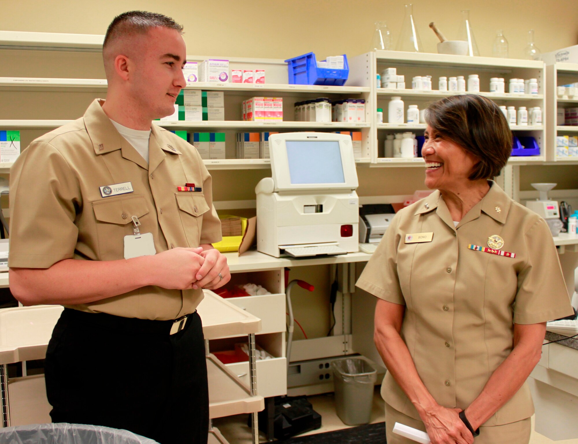 Hospitalman Dalton Terrell, pharmacy technician, Naval Health Clinic Charleston, describes the daily operations of and services provided at NHCC's pharmacy, for Rear Adm. Raquel Bono, chief, Navy Medical Corps and director, National Capital Region Medical Directorate , Aug. 21, 2015 during Bono's visit to NHCC. Bono also met with NHCC command leadership, visited various departments throughout the clinic, and spoke with staff members about the future of Navy medicine and what's on the horizon for military health care through the collaboration of joint service operations. (Navy photo/ Hospitalman Mark Simon)
