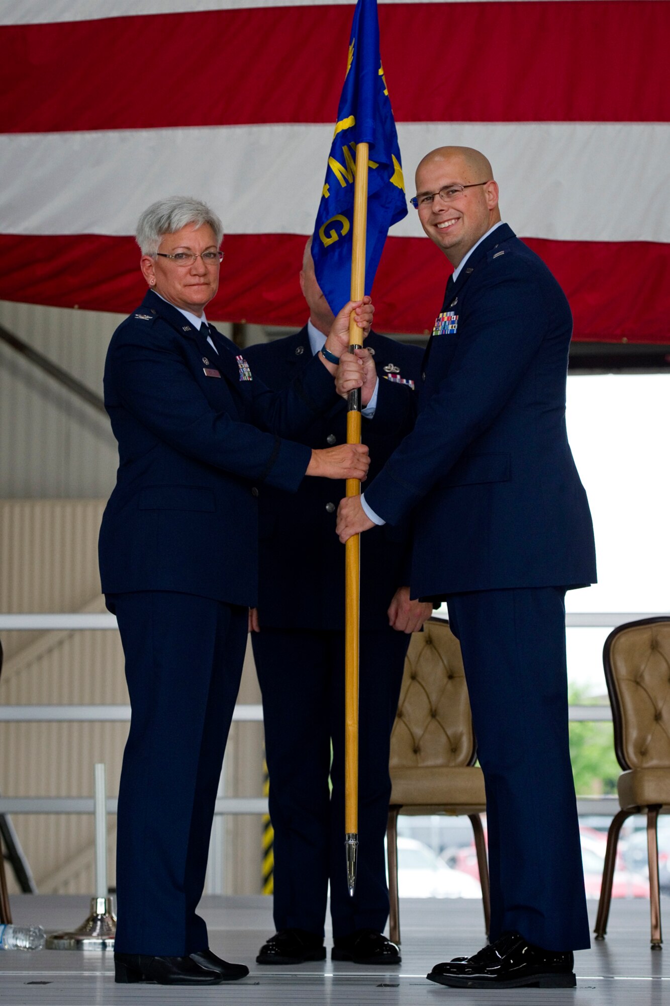 Col. Anna Schulte, 434th Maintenance Group commander, presents a Maintenance Operations Section guidon to Capt. Theodore Karagias, 434th MOS commander, during a change of command ceremony at Grissom Air Reserve Base, Ind., Aug. 9, 2015. The 434th MOS is part of the 434th MSG which also encompasses two squadrons including over 560 personnel with a mission to provide vital support to the 434th Air Refueling Wing. (U.S. Air Force photo/Senior Airman Jami Lancette)