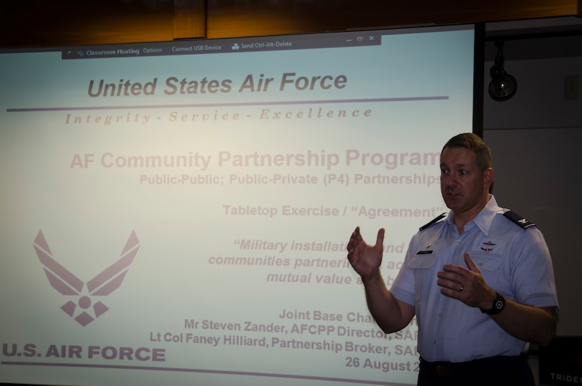 Col. Robert Lyman, Joint Base Charleston commander, delivers opening remarks during the Air Force Community Partnership Program Joint Base Charleston Tabletop Exercise, August 26, 2015 at Trident Tech College in North Charleston, S.C. The JB Charleston TTX was the culmination of several planning meetings where a core group of installation and community leaders shared information on existing partnerships, organizational needs and capabilities/resources and identified potential partnering opportunities to reduce operating and service costs or reduce risks, while retaining or enhancing quality. The exercise served as a forum for members of the installation and local communities to engage in focused discussions related to the concept of partnering and clearly identify the next steps required to make the opportunities become reality. (U.S. Air Force photo/Staff Sgt. AJ Hyatt)