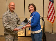 Colonel Jimmy Canlas, 437th Air Wing vice commander, presents an award to Stacy Pearsall, founder of the Veteran’s Portrait Project, for her support  of Women’s Equality Day at the Charleston Club on Joint Base Charleston, SC, Aug. 26, 2015. Pearsall, a prior service Air Force photojournalist with the 1st Combat Camera Squadron, was the first and only woman in the military to win the Department of Defense Military Photographer of the year twice. (U.S. Air Force photo/Airman 1st Class Thomas T. Charlton)