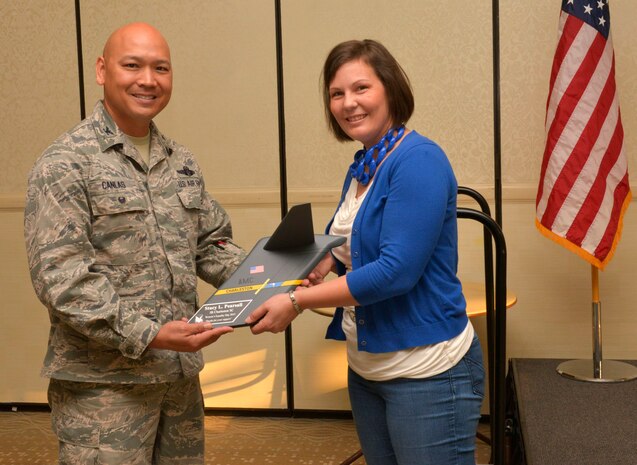 Colonel Jimmy Canlas, 437th Air Wing vice commander, presents an award to Stacy Pearsall, founder of the Veteran’s Portrait Project, for her support  of Women’s Equality Day at the Charleston Club on Joint Base Charleston, SC, Aug. 26, 2015. Pearsall, a prior service Air Force photojournalist with the 1st Combat Camera Squadron, was the first and only woman in the military to win the Department of Defense Military Photographer of the year twice. (U.S. Air Force photo/Airman 1st Class Thomas T. Charlton)
