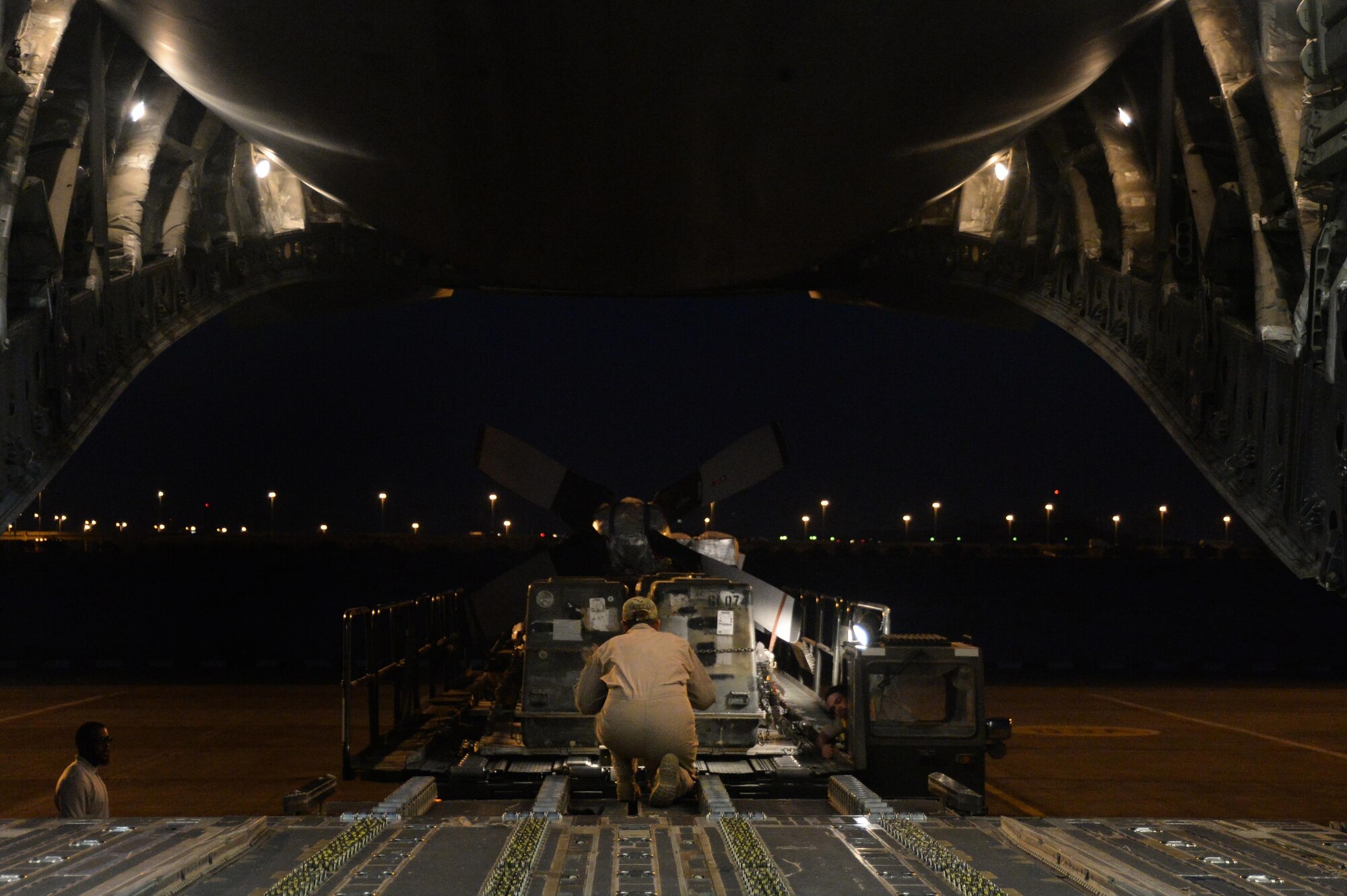 U.S. Air Force Senior Airman Rebecca, 816th Expeditionary Airlift Squadron loadmaster, guides a pay-loader to load cargo on board a C-17 Globemaster III in support of Operation Inherent Resolve in Kuwait, August 14, 2015. OIR is the military intervention against Daesh. (U.S. Air Force photo by Staff Sgt. Sandra Welch) 