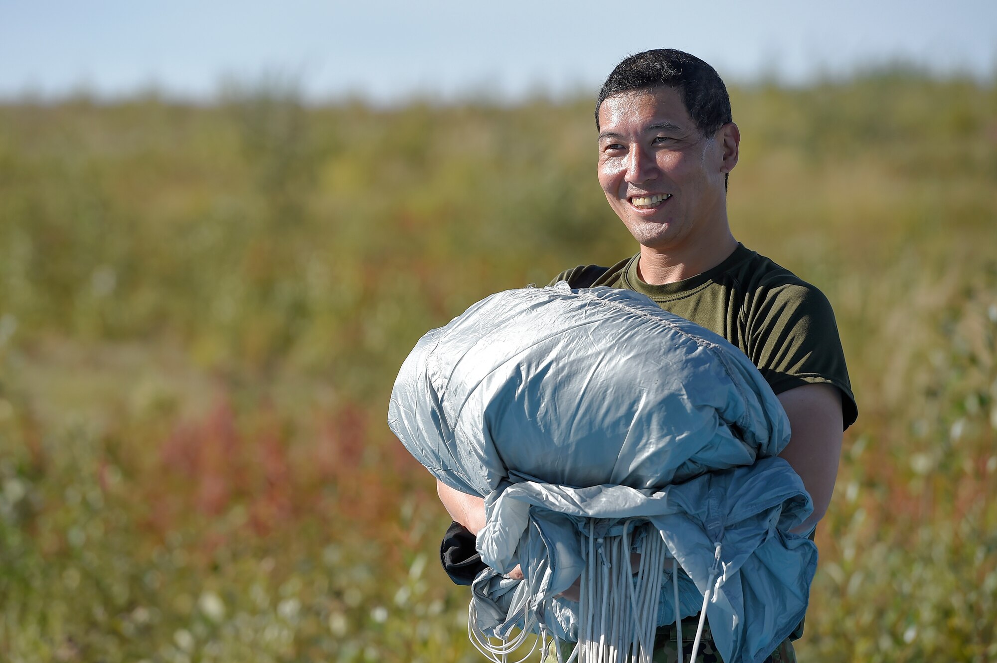 A Japanese Ground Self-Defense Force soldier recovers his parachute after conducting high altitude-low opening jump training over Malemute drop zone, Joint Base Elmendorf-Richardson, Alaska, Aug. 24, 2015. JGSDF and U.S. Army paratroopers conducted the practice jump utilizing Royal Australian and U.S. Air Force aircraft as part of Pacific Airlift Rally 2015, a biennial, multilateral tactical military symposium designed to enhance military airlift interoperability and cooperation between nations of the Pacific region for future humanitarian missions. (U.S. Air Force photo/Alejandro Pena)

