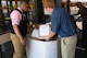 Calvin Teller, the commissary’s customer service ambassador (left), and Daniel Schroeder, the asset commissary officer at Holloman Air Force Base, stack brown paper bags full of donated food into a collection bin in the commissary here Aug 12. The food collected is a part of the Feds Feed Families program helping feed families in need and filling local food shelves. (U.S. Air Force photo by Amn Randahl J. Jenson)  