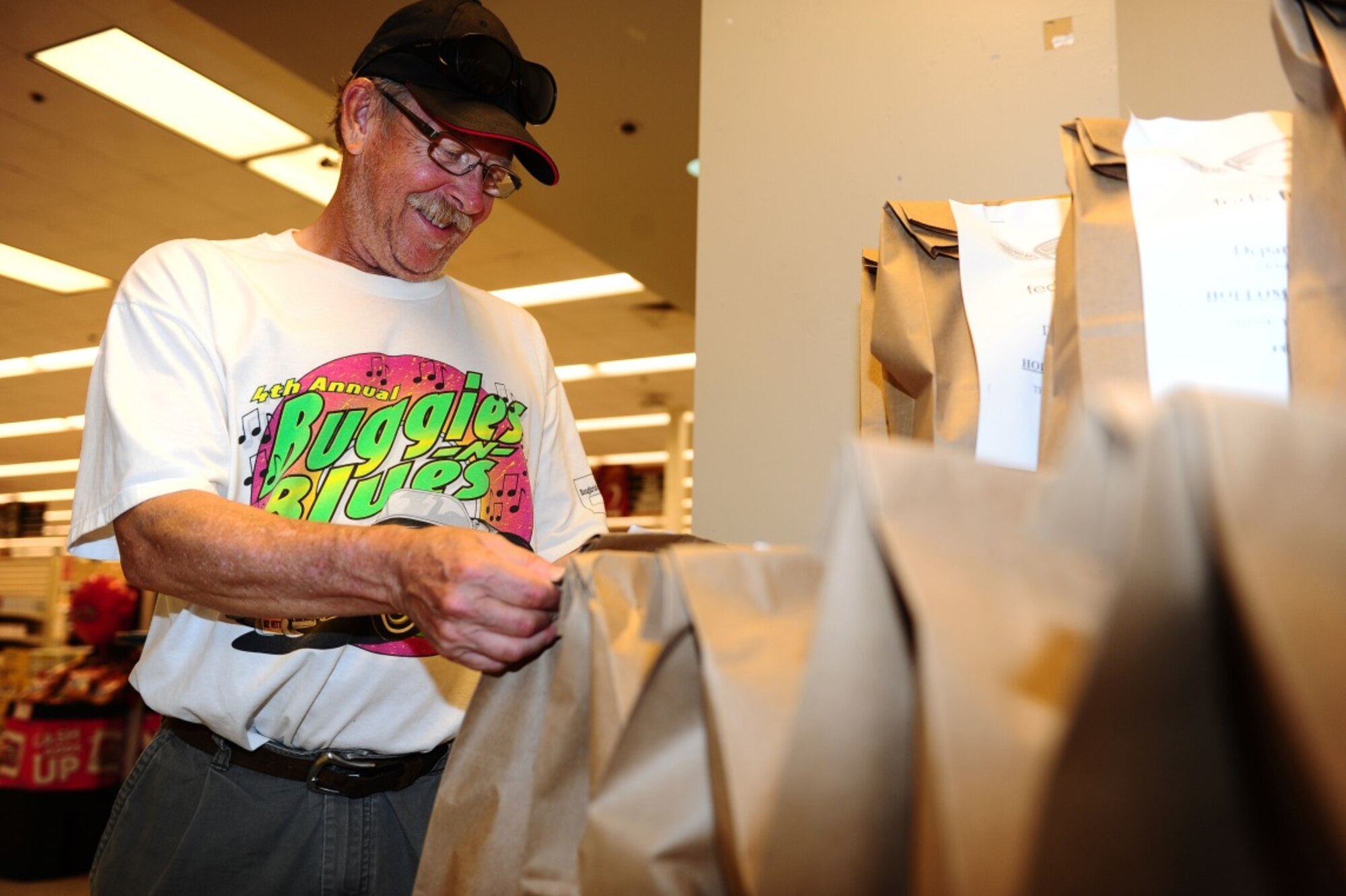 Richard Lubke, a retired Air Force flight engineer, examines a Feds Feed Families food bag in the commissary at Holloman Air Force Base on Aug 18. For less than $10, commissary shoppers, like Lubke, can help feed a  local family in need. (U.S. Air Force photo by Amn Randahl J. Jenson)