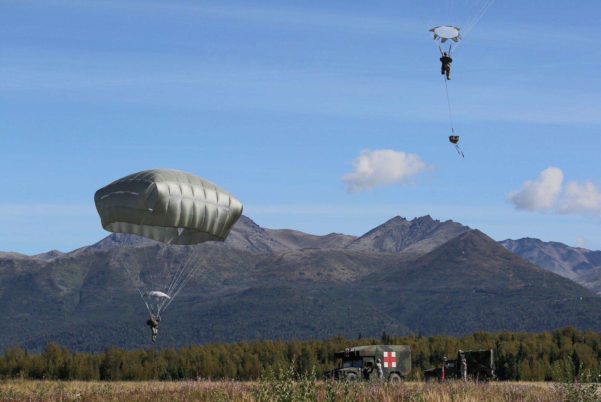 Paratroopers assigned to 1st Battalion (Airborne), 501st Infantry Regiment, 4th Infantry Brigade Combat Team (Airborne), 25th Infantry Division, U.S. Army Alaska, descend during a practice jump over Malemute drop zone, Joint Base Elmendorf-Richardson, Alaska, Aug. 24, 2015. Japanese Ground Self-Defense Force and U.S. Army paratroopers conducted the practice jump utilizing Royal Australian and U.S. Air Force aircraft as part of Pacific Airlift Rally 2015, a biennial, multilateral tactical military symposium designed to enhance military airlift interoperability and cooperation between nations of the Pacific region for future humanitarian missions. (U.S. Air Force photo/Alejandro Pena)