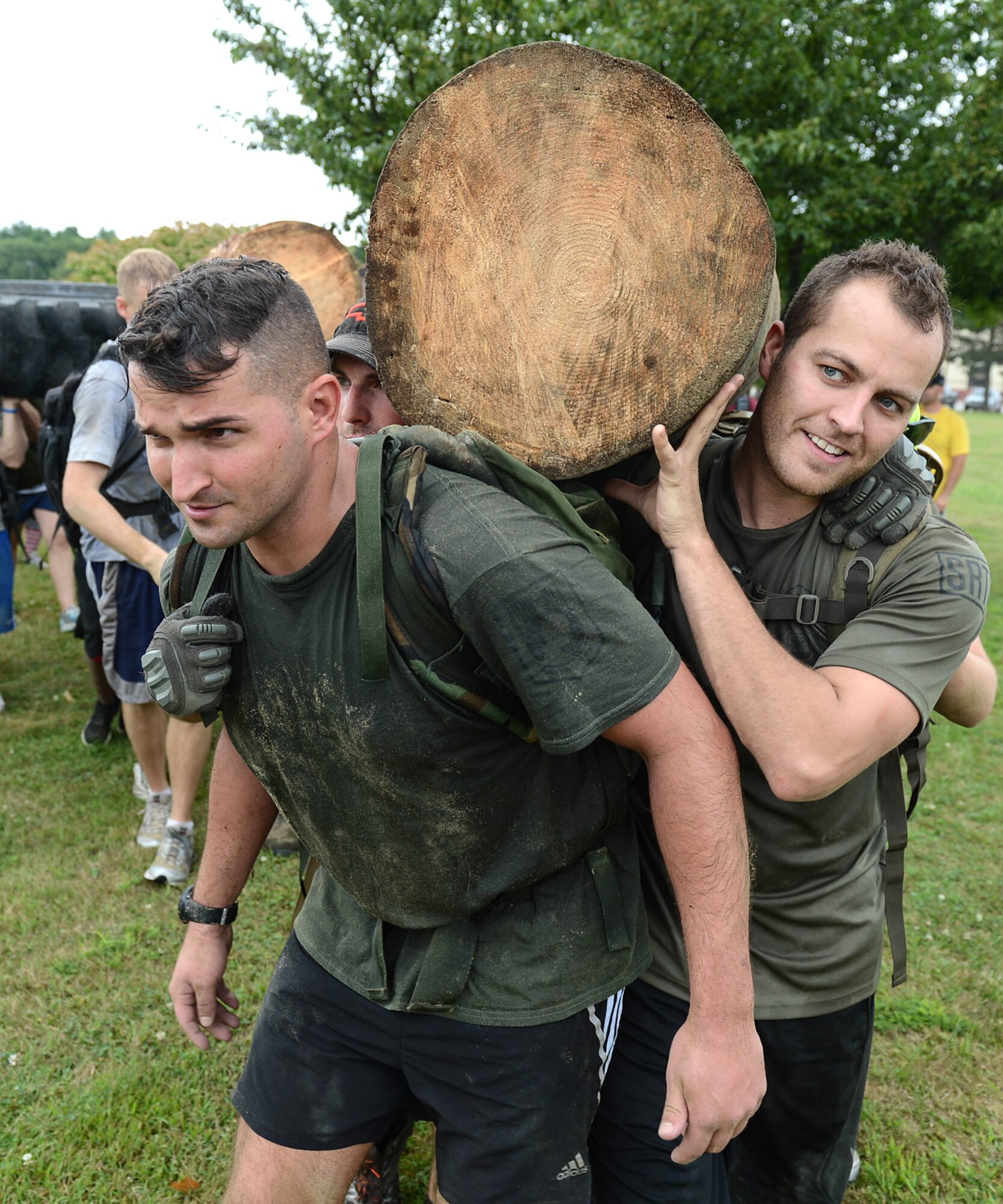 Staff Sgts. Robert Osborne, left, and Matthew Marquart, both members of the 66th Security Forces Squadron, carry a log on their shoulders along with other Airmen as part of a Team Cohesion Challenge Aug. 24. The challenge, known as GORUCK, was held to challenge, teach and inspire Airmen in small teams to work together in a physical, social and mental fitness activity. (U.S. Air Force photo by Jerry Saslav)