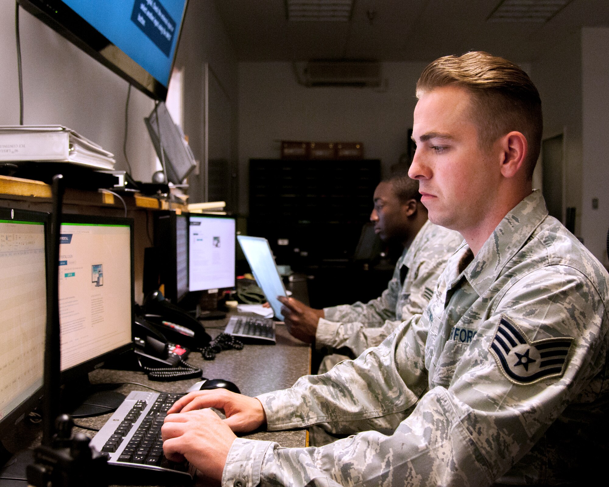 Staff Sgt. Aaron Smith and Senior Airman Joseph bates, 90th Logistics Readiness Squadron Traffic Control Function controllers, monitor computer systems, which allow them to update the 90th Missile Wing about road conditions in its missile complex, Aug. 5, 2015, on F.E. Warren Air Force Base, Wyo. TCF Airmen operate 24/7 to ensure the 90th Missile Wing has up-to-date road conditions. (U.S. Air Force photo by Senior Airman Jason Wiese)