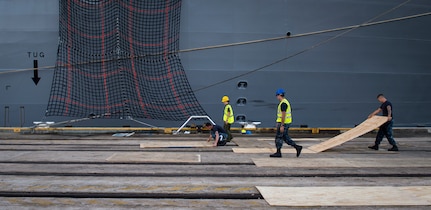 Sailors, Marines and civilians with the Navy Munitions Command Unit Charleston and Marine Corps Systems Command prepare the loading zone for uploading cargo to the USNS Lewis and Clark (T-AKE-1) March, 25, 2015, at Naval Weapons Station Wharf Alpha, Charleston, S.C. The Lewis and Clark is a replenishment naval vessel. In 2012, USNS Lewis and Clark became one of 12 ships that comprise the United States Marine Corps Maritime Prepositioning Program. Prepositioning ships provides quick and efficient movement of military equipment/supplies between operating areas without reliance on other nations' transportation networks. These ships assure U.S. regional combatant commanders they will have what they need to quickly respond in a crisis - anywhere, anytime. (U.S. Air Force photo/Airman 1st Class Clayton Cupit)