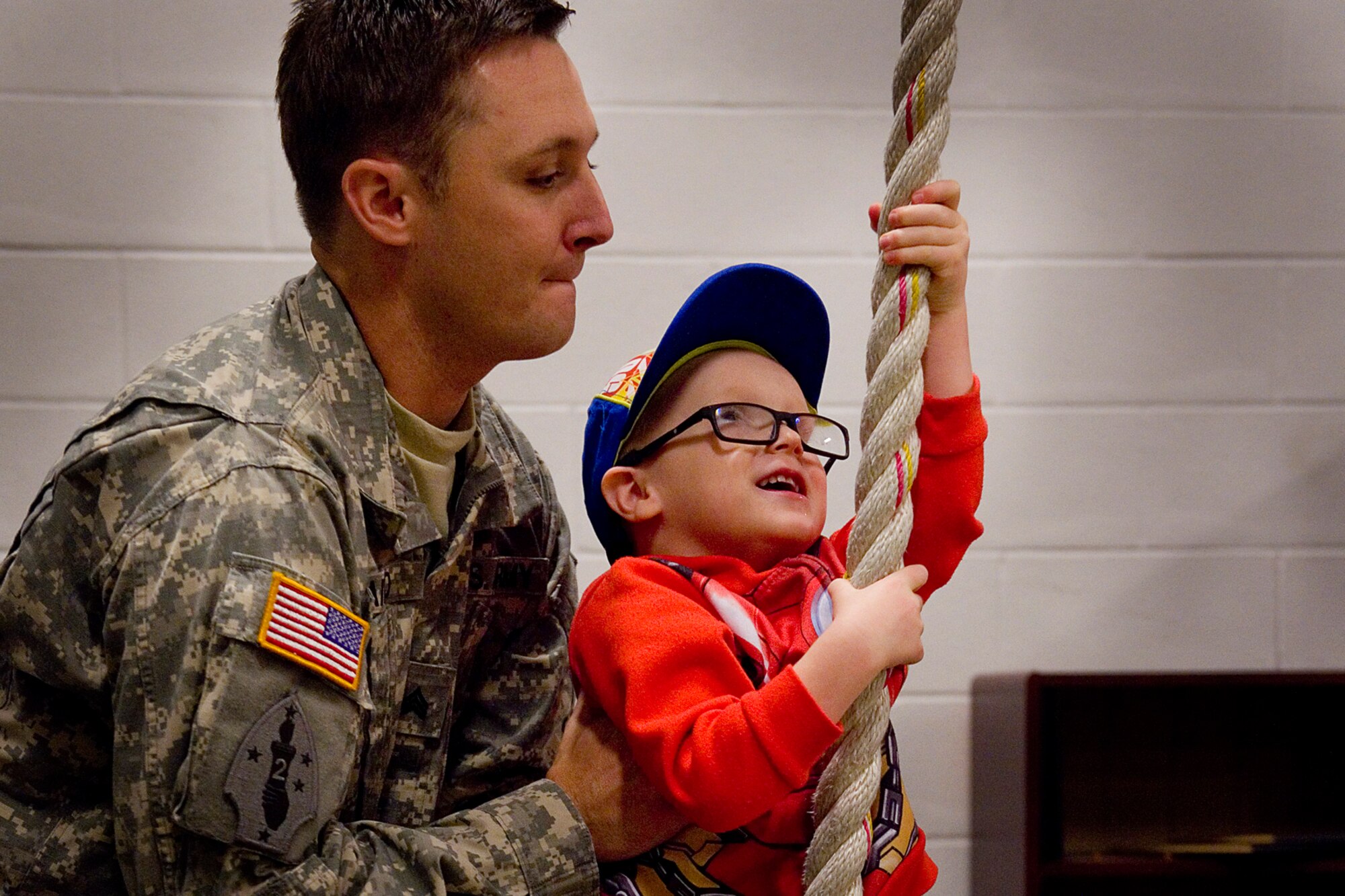 U.S. Army Sgt. Eric Laird, 316th Psychological Operations Company, helps his son Ethan climb a rope Aug 24, 2015 at the Army Reserve Center located at Grissom Air Reserve Base, Ind. Soldiers from the 316th PSOP are preparing for a nine-month deployment supporting the Combined Joint Task Force Horn of Africa. (U.S. Air Force photo/Tech. Sgt. Douglas Hays)