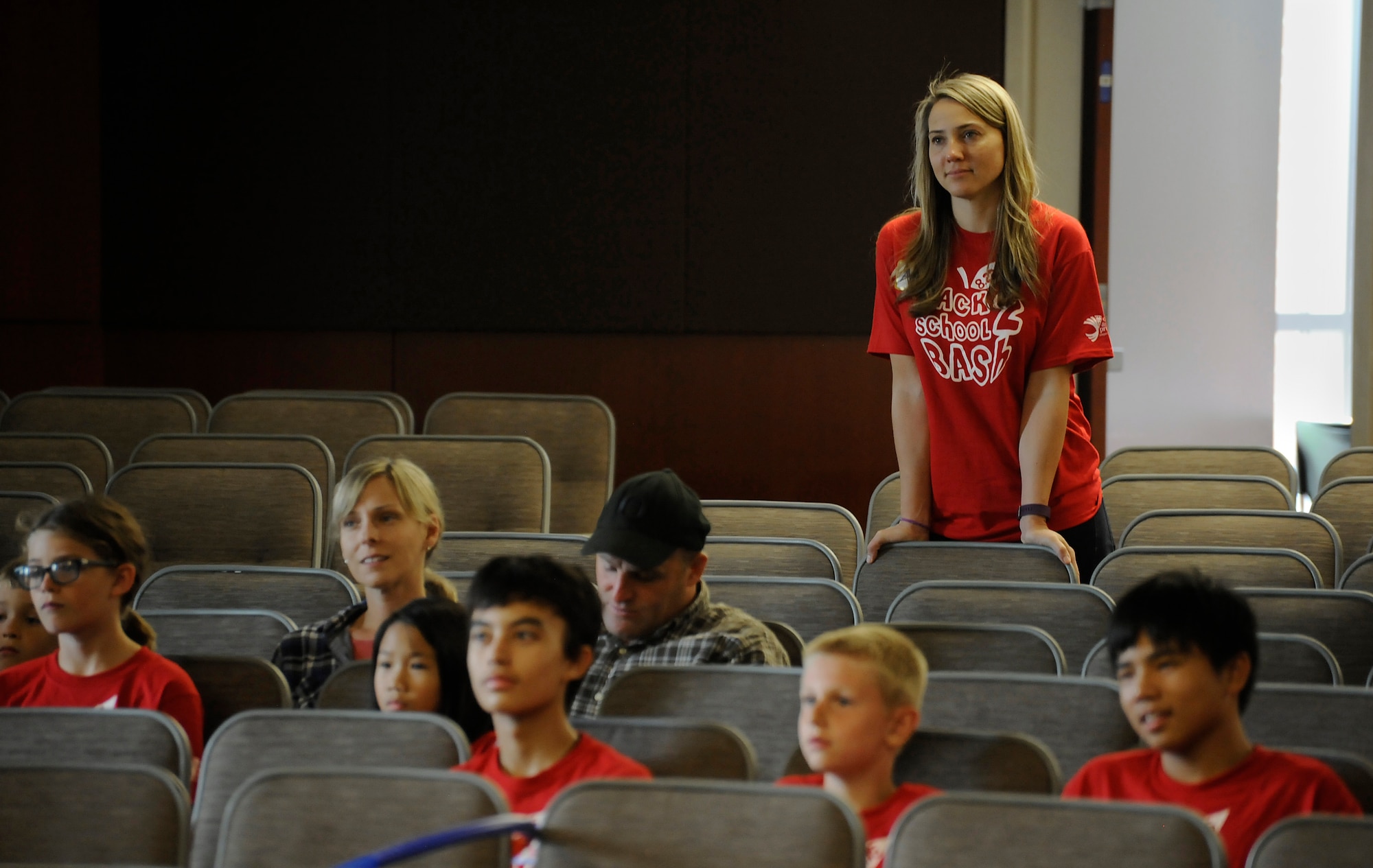 Amy Conroy, 142nd Fighter Wing Family Programs Manager, listens to speaker Jonathan Catherman address those attending the Back2School Bash at Camp Withycombe, Ore., Aug. 22, 2015. (U.S. Air National Guard photo by Tech. Sgt. John Hughel, 142nd Fighter Wing Public Affairs/Released)
