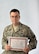 U.S. Air Force Tech. Sgt. Scott Bettencourt, a pharmacy flight chief with the 55th Medical Support Squadron, poses with a certificate he received from Jamal Jung Kunwar, chief conservation of Chitwan National Park, Nepal, after spending two weeks building an elephant corral on Aug. 26, Offutt Air Force Base, Neb.  The corrals are replacing the chains used by elephant handlers to keep their working elephants in place.  Corrals have been proven to improve the health and demeanor of the elephants and are being widely adopted by working elephant handlers throughout the world.  (U.S. Air Force photo by Josh Plueger/Released)