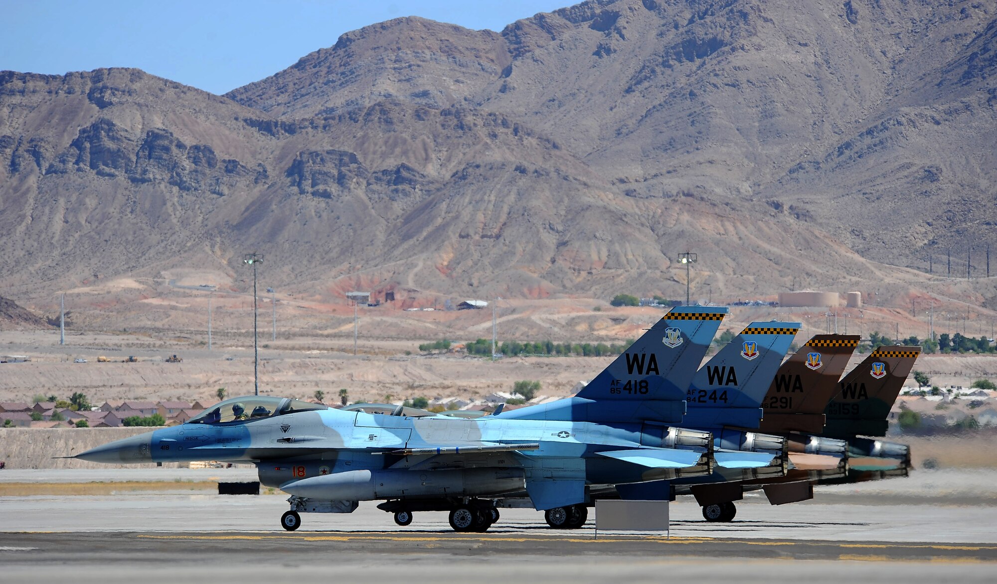 U.S. Air Force F-16 Fighting Falcons assigned to the 64th Aggressor Squadron wait to take off during Red Flag 15-4 at Nellis Air Force Base, Nev., Aug. 24, 2015. Red Flag involves a series of intense air-to-air combat exercises designed to prepare U.S. and allied forces for future real world conflicts. (U.S. Air Force photo by Senior Airman Thomas Spangler)