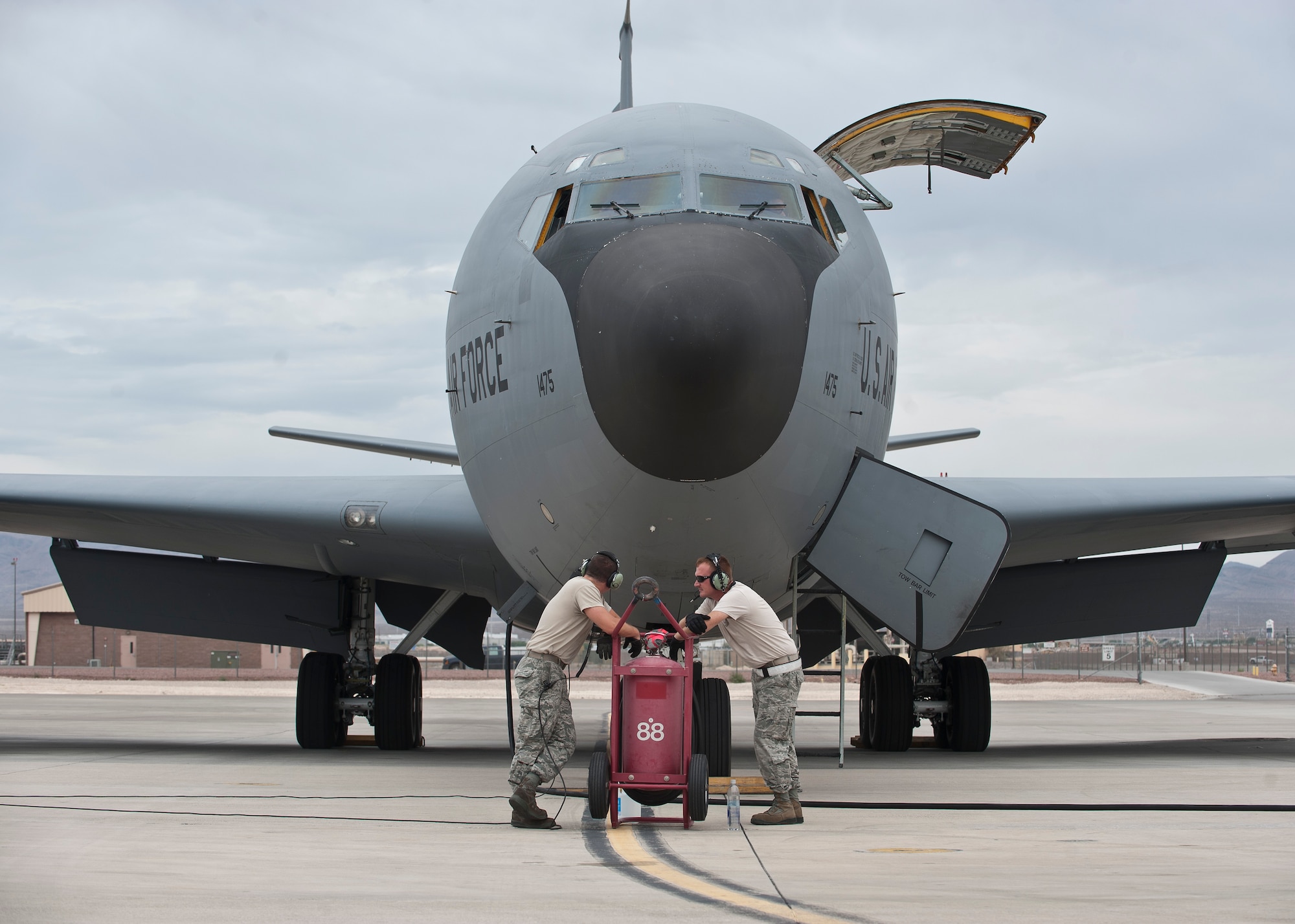 Two maintainers assigned to the 22nd Aircraft Maintenance Squadron, McConnell Air Force Base, Kan., wait for the aircrew of a KC-135 Stratotanker to finish pre-flight inspections prior to a Red Flag 15-4 sortie at Nellis AFB, Nev., Aug. 25, 2015. Red Flag involves a variety of attack, fighter, bomber, reconnaissance, electronic warfare, airlift support and search and rescue aircraft. (U.S. Air Force photo by Staff Sgt. Siuta B. Ika)