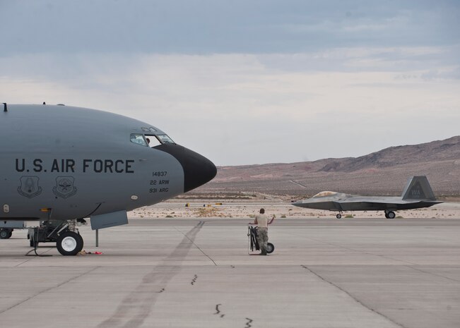A maintainer assigned to the 22nd Aircraft Maintenance Squadron, McConnell Air Force Base, Kan., watches an F-22 Raptor taxi during Red Flag 15-4 at Nellis AFB, Nev., Aug. 25, 2015. Red Flag involves a variety of attack, fighter, bomber, reconnaissance, electronic warfare, airlift support and search and rescue aircraft. (U.S. Air Force photo by Staff Sgt. Siuta B. Ika)