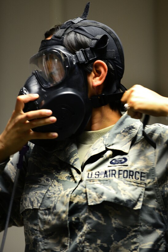 U.S. Air Force Airman 1st Class Danielle, 30th Intelligence Squadron imagery analyst, dons a gas mask during a fit-test at Langley Air Force Base, Va., Aug. 18, 2015. The test is a requirement of all Service members prior to deployment. (U.S. Air Force photo by Senior Airman Kimberly Nagle/Released)(Last name withheld for operational security purposes)