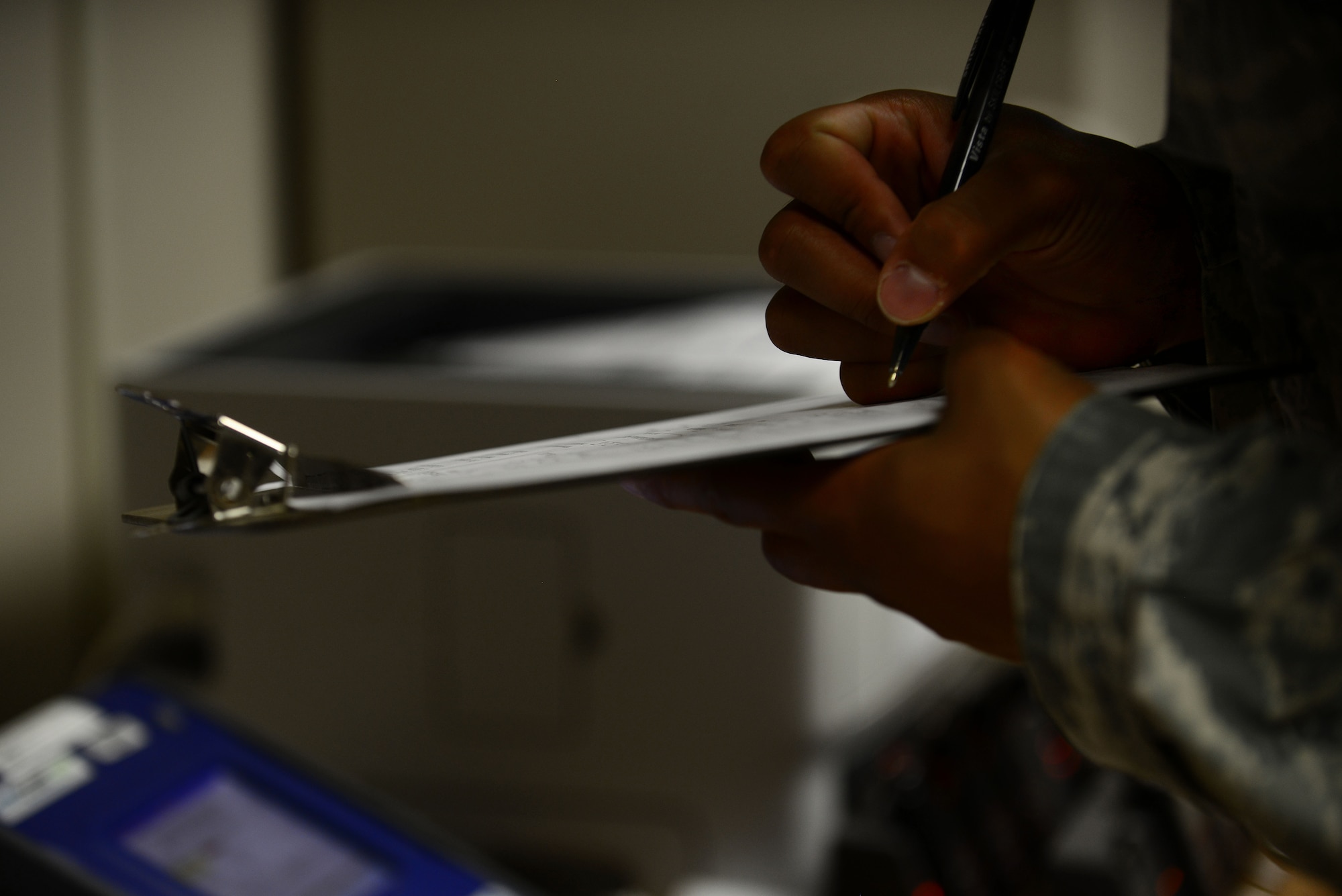 A U.S. Air Force Airman annotates gas mask fit-test scores at the bioenvironmental office at Langley Air Force Base, Va., Aug. 18, 2015. The technicians observe Service members performing the test while annotating the scores of the breathing techniques with the mask on. (U.S. Air Force photo by Senior Airman Kimberly Nagle/Released)