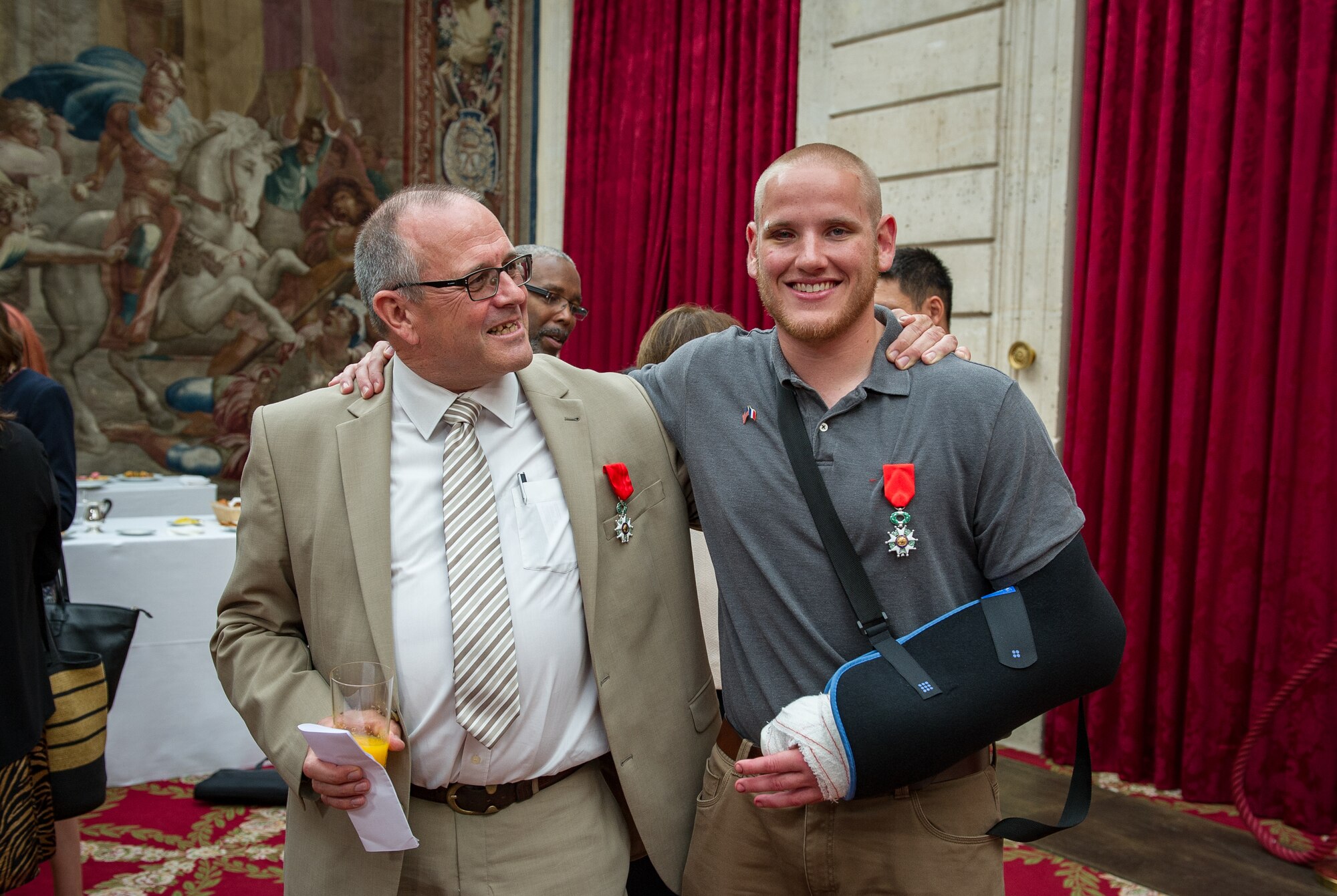 Airman 1st Class Spencer Stone poses with Chris Norman, fellow train passenger, after a Legion of Honor ceremony at the ??lys??e in Paris Aug. 24, 2015. Stone was on vacation with his childhood friends, Aleksander Skarlatos and Anthony Sadler, when an armed gunman entered their train carrying an assault rifle, a handgun and a box cutter. The three friends, with the help of a British passenger, subdued the gunman after his rifle jammed. Stone???s medical training prepared him to begin treating wounded passengers while waiting for the authorities to arrive. Stone is an ambulance service technician with the 65th Medical Operations Squadron stationed at Lajes Field, Azores. (U.S. Air Force photo/Tech. Sgt. Ryan Crane)