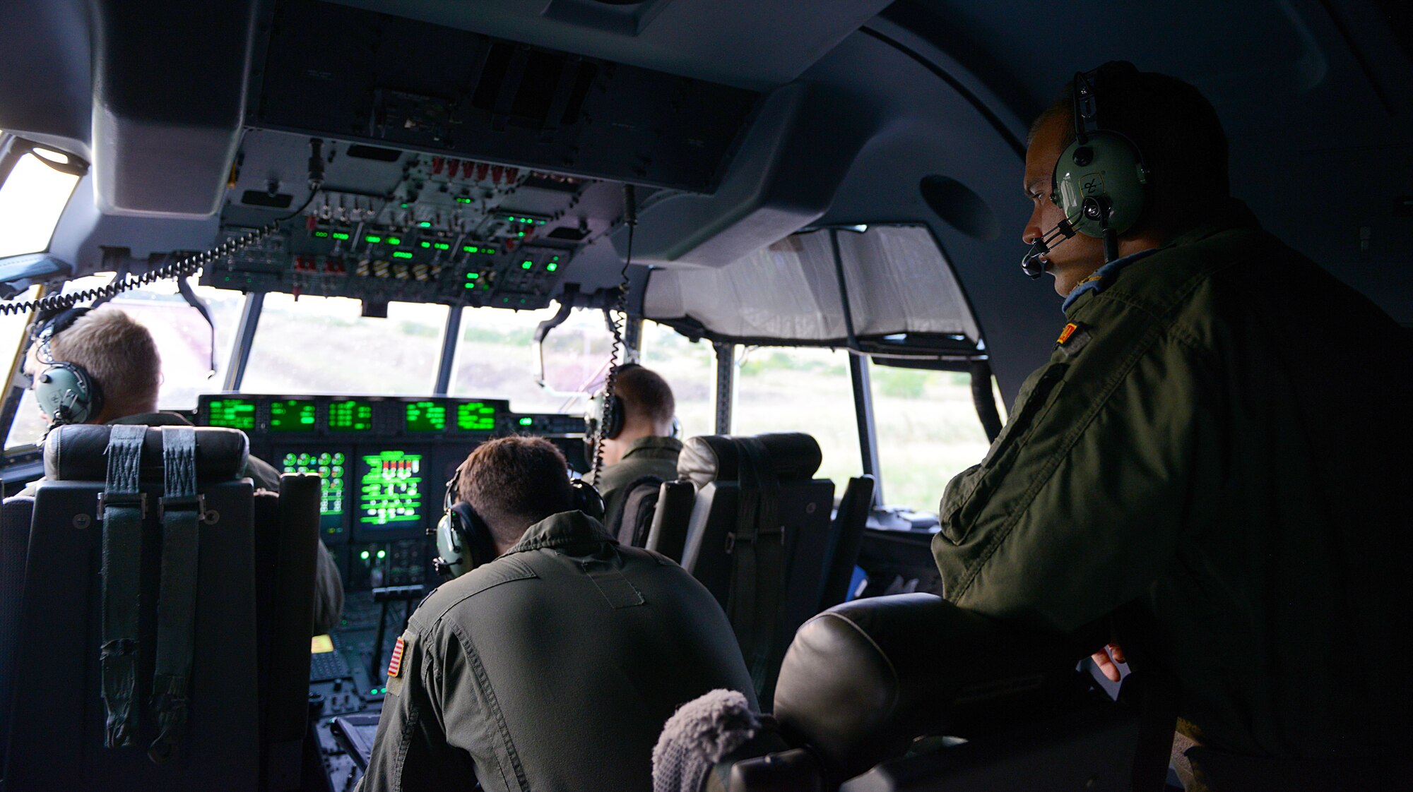 Romanian air force 2nd Lt. Sipos Claudiu, 902nd Transportation and Reconnaissance Squadron C-27J Spartan pilot, watches U.S. Air Force C-130J Super Hercules pilots perform pre-flight checks Aug. 18, 2015, at Otopeni Air Base, Romania. To obtain a better understanding of how each other operate, pilots from the U.S. Air Force and Romanian air force flew together during exercise Carpathian Summer, a bilateral training event designed to increase readiness and interoperability between the forces. (U.S. Air Force photo/Senior Airman Timothy Moore)