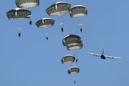 Paratroopers assigned to 1st Battalion (Airborne), 501st Infantry Regiment, 4th Infantry Brigade Combat Team (Airborne), 25th Infantry Division, U.S. Army Alaska descend after jumping out of a U.S. Air Force C-130 Hercules, assigned to the 374th Wing from Yokota Air Base, over Malemute drop zone, Joint Base Elmendorf-Richardson, Alaska, Aug. 24, 2015. Japanese Ground Self-Defense Force and U.S. Army paratroopers conducted the practice jump utilizing Royal Australian and U.S. Air Force aircraft as part of Pacific Airlift Rally 2015, a biennial, multilateral tactical military symposium designed to enhance military airlift interoperability and cooperation between nations of the Pacific region for future humanitarian missions. (U.S. Air Force photo by Alejandro Pena/Released)
