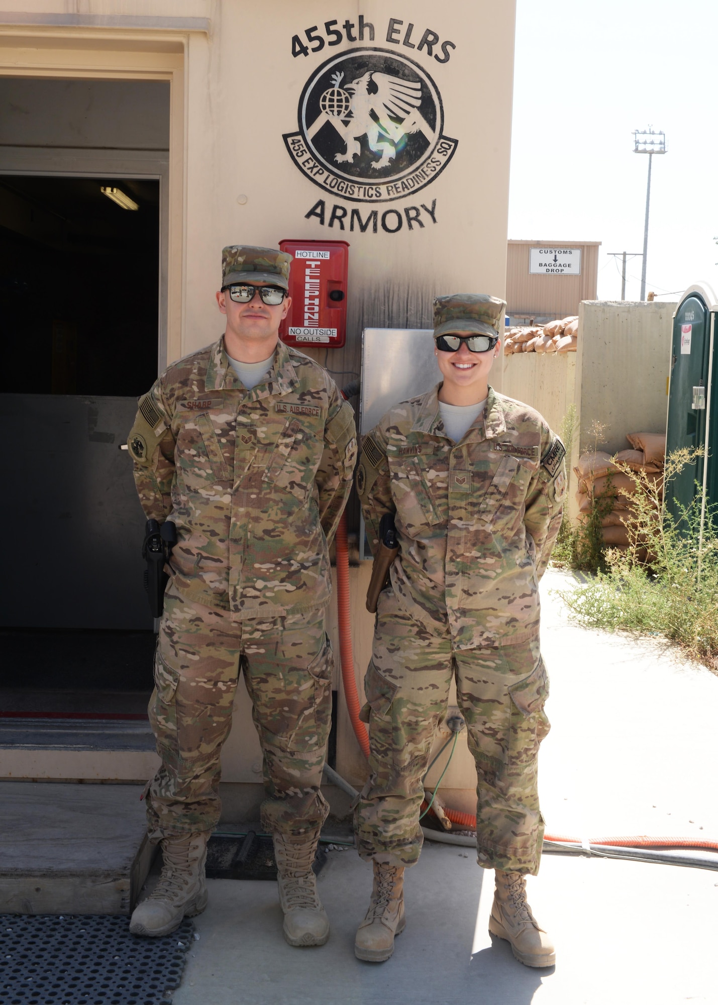 U.S. Air Force Staff Sgt. Joshua Sharp and Brenda Hawkins, 455th Expeditionary Logistics Readiness Squadron armory team, pose for a photo Aug. 26, 2015, at Bagram Airfield, Afghanistan. The team is responsible for issuing weapons to Airmen of the 455th AEW that do not deploy with but require a weapon during their deployment. (U.S. Air Force photo by Senior Airman Cierra Presentado/Released)