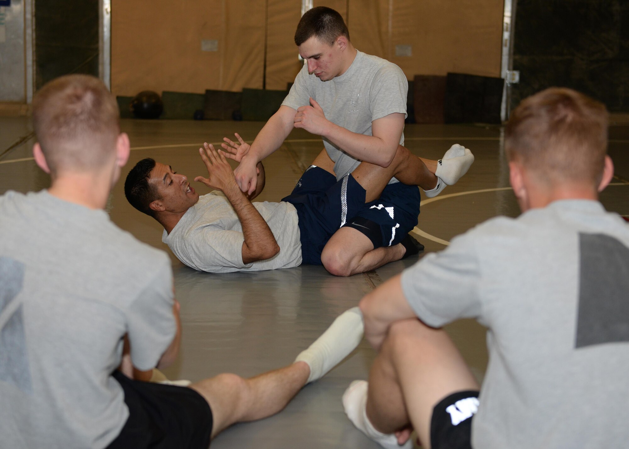 U.S. Air Force TSgt. Roman-Rivera, 455th Expeditionary Security Forces Squadron non-commissioned officer in charge of Check Six, and Airman 1st Class Nicholas Wright, 455 ESFS fly away security team member, demonstrate a combatives move during a combative class Aug. 25, 2015, at Bagram Airfield, Afghanistan. Both men are martial arts instructors and volunteer to teach interested military members how to defend themselves while in the AOR. (U.S. Air Force photo by Senior Airman Cierra Presentado/Released)