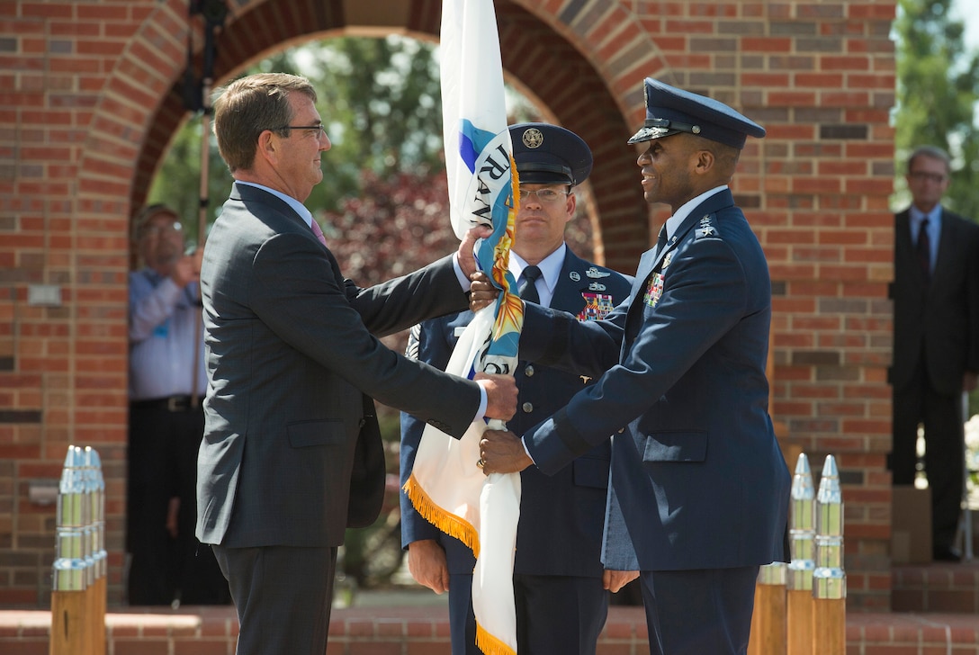Defense Secretary Ash Carter hands the U.S. Transportation Command flag to Air Force Gen. Darren W. McDew as McDew assumes leadership of the command during a ceremony on Scott Air Force Base, Ill., Aug. 26, 2015. DoD photo by U.S. Air Force Master Sgt. Adrian Cadiz