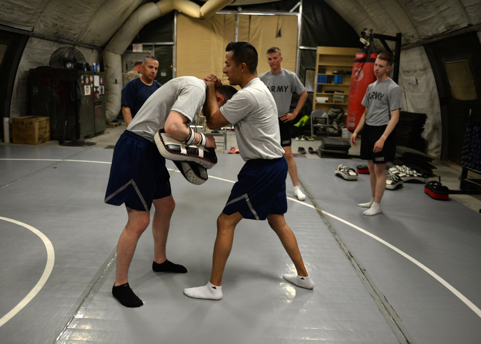 U.S. Air Force TSgt. Roman-Rivera, 455th Expeditionary Security Forces Squadron non-commissioned officer in charge of Check Six, and Airman 1st Class Nicholas Wright, 455 ESFS fly away security team member, demonstrate a combatives move during a combative class Aug. 25, 2015, at Bagram Airfield, Afghanistan. Both men are martial arts instructors and volunteer to teach interested military members how to defend themselves while in the AOR. (U.S. Air Force photo by Senior Airman Cierra Presentado/Released)
