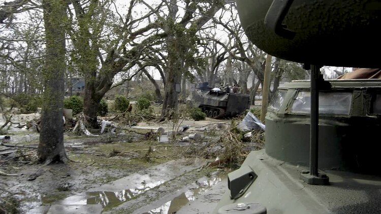 Marines and sailors of a reaction team from Naval Construction Battalion Center ride in amphibious tractors through the ruins of neighborhoods in Southern Mississippi after the devastation of Hurricane Katrina in late August 2005. The reaction team was credited with the rescue of more than 200 people. (Courtesy Photo)