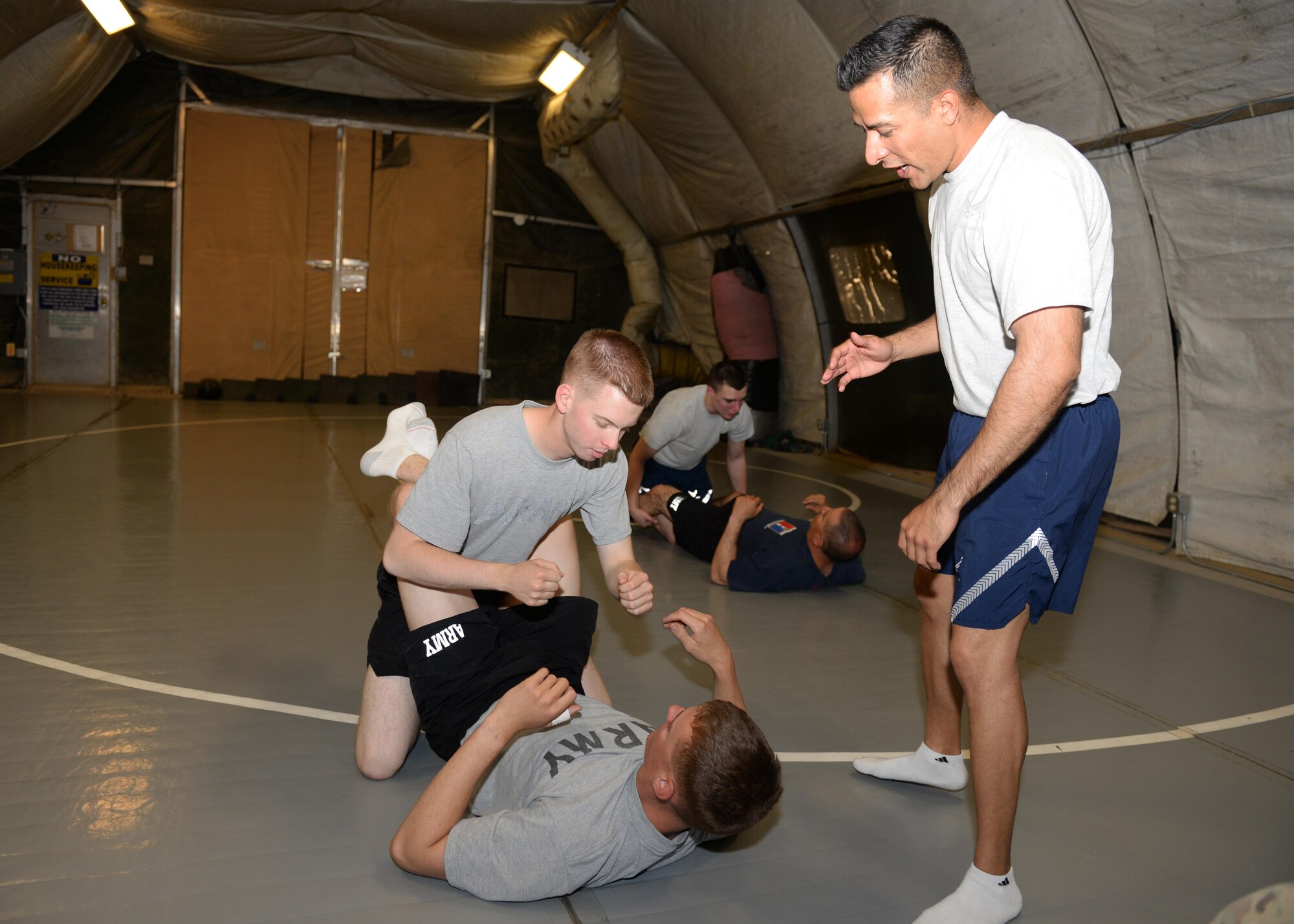 U.S. Air Force Tech Sgt. Roman-Rivera, 455th Expeditionary Security Forces Squadron non-commissioned officer in charge of Check Six, teaches combatives to U.S. Army Spcs. Cameron Hicks and Cody Hougnon, Task Force-Solid personal security detachment team members, Aug. 25, 2015, at Bagram Airfield, Afghanistan. Roman-Rivera teaches combatives to military members on Bagram that are interested in learning how to defend themselves while in the AOR. (U.S. Air Force photo by Senior Airman Cierra Presentado/Released)