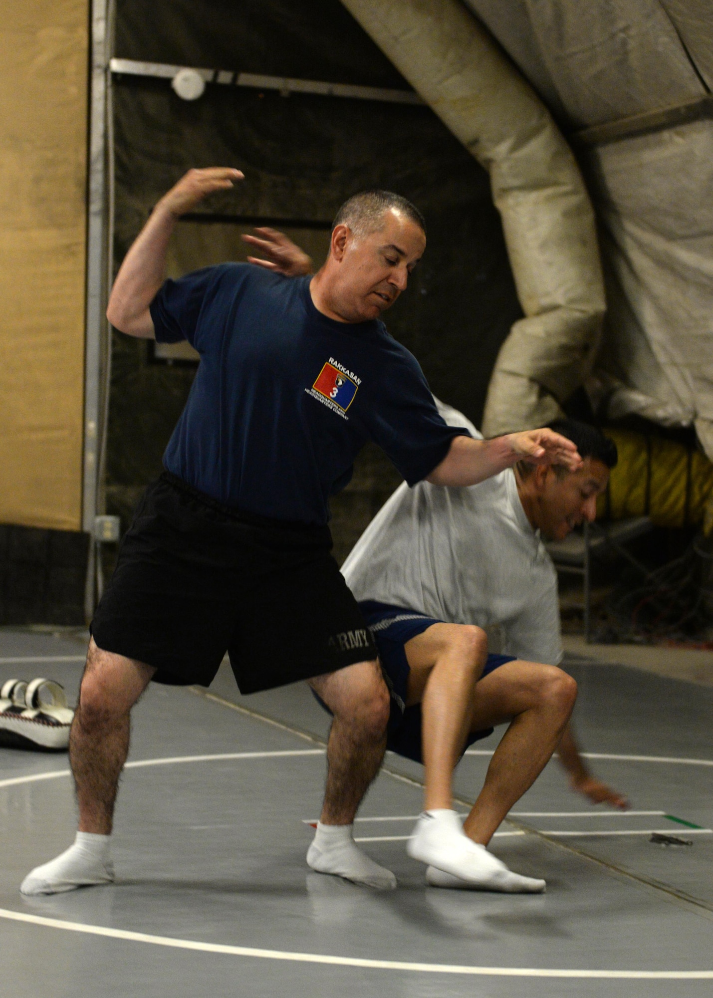 U.S. Army Sergeant 1st Class Phillip Beltran, Task Force Solid train advise assist team member, demonstrates a combatives move on martial arts instructor U.S. Air Force TSgt. Yamil Roman-Rivera, 455th Expeditionary Security Forces Squadron non-commissioned officer in charge of Check Six, during a combatives class Aug. 25, 2015, at Bagram Airfield, Afghanistan. Roman-Rivera teaches combatives to military members on Bagram that are interested in learning how to defend themselves while in the AOR. (U.S. Air Force photo by Senior Airman Cierra Presentado/Released)