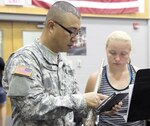 Spec. Michael Kwak, 323rd Army Band flutist, reviews music with a flute player during La Vernia High School’s annual summer band camp Aug. 3-7.