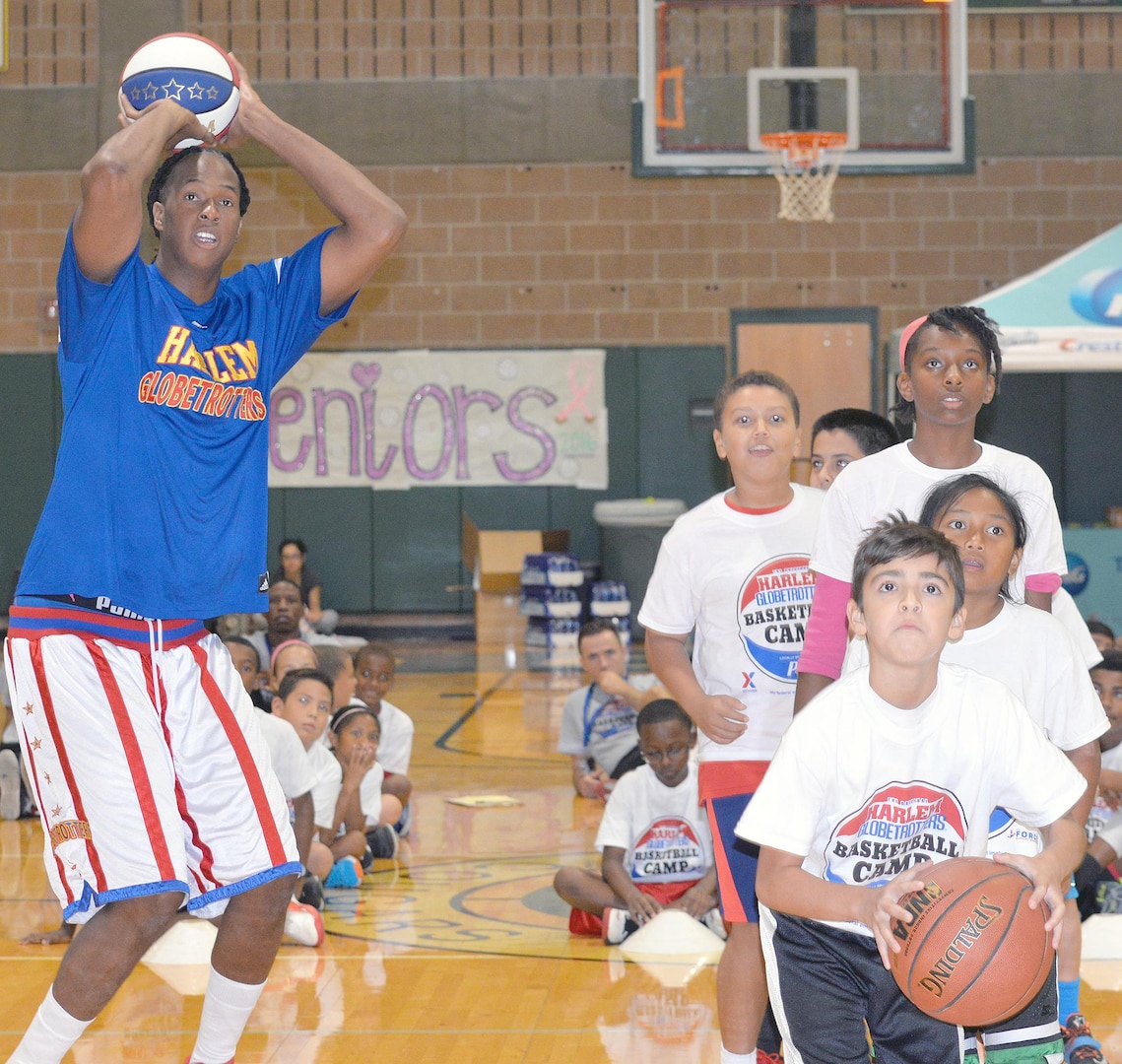 Jermaine “Stretch” Middleton shoots baskets with children during a basketball camp held at Cole High School on JBSA-Fort Sam Houston Aug. 19.