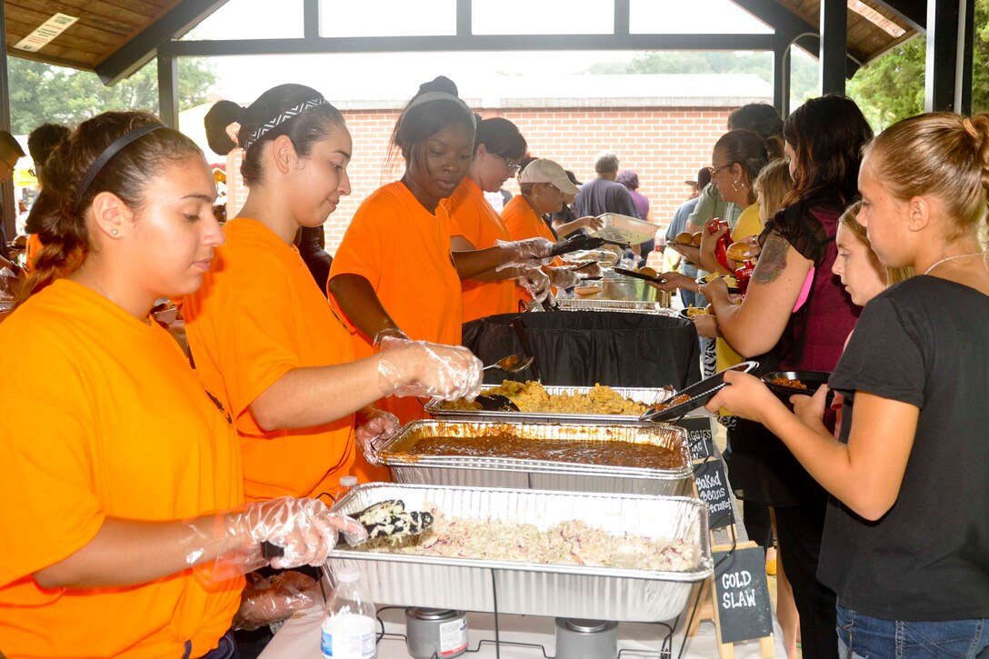 Civilian and Marine volunteers serve a meal catered by Mission BBQ during the Civilian Appreciation Annual Picnic at Barnett Field aboard Marine Corps Base Quantico, Aug 20. The event provides an opportunity to recognize the contributions of civilian employees and their families. 
