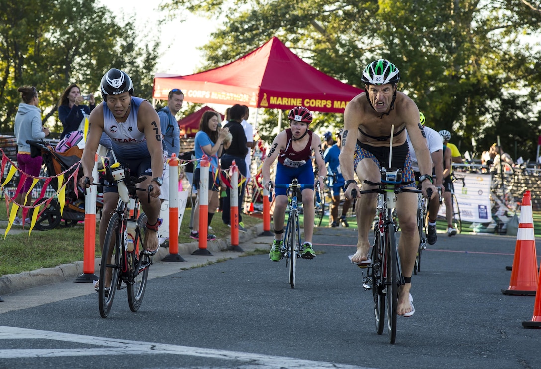 Athletes begin their cycling portion of the Marine Corps Marathon's Quantico Triathlon, Quantico, Va., Aug. 22, 2015. The Triathlon is a three part event consisting of a 750 meter open water swim, 20K cycle tour, and 5K run to complete the entire race. (U.S. Marine Corps photo by Lance Cpl. Elisha N. Peake/Released)