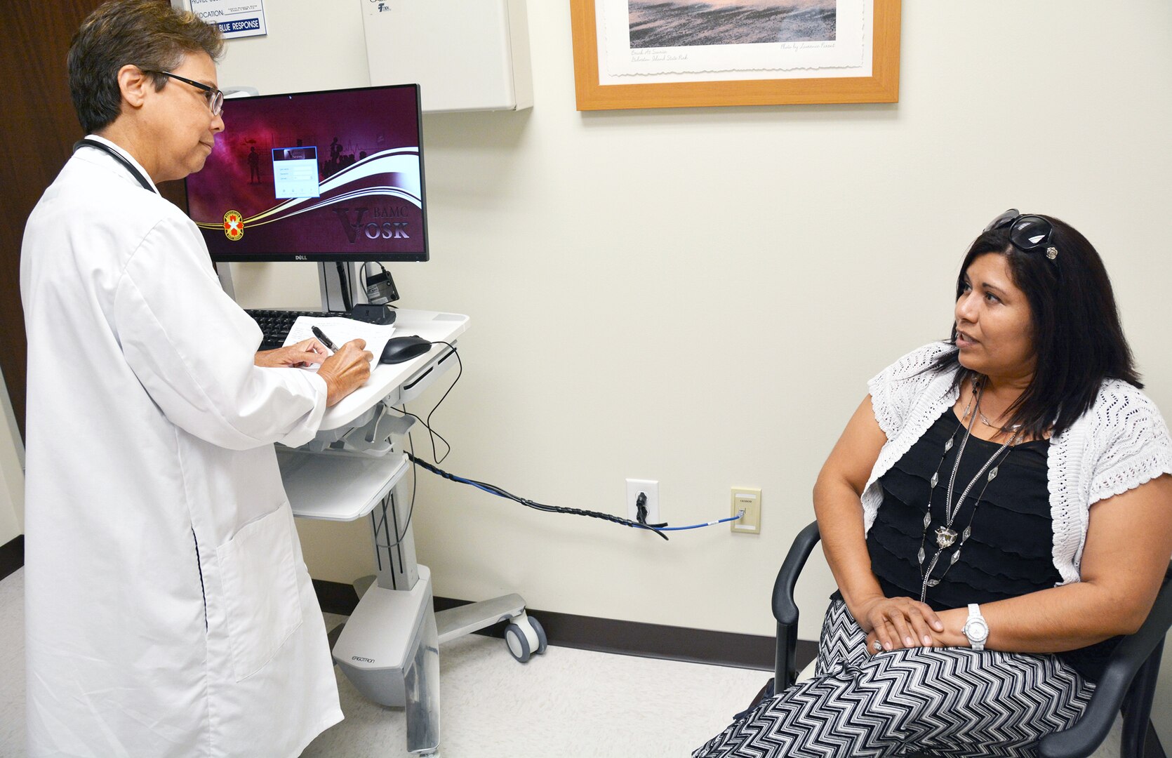 Dr. Kathryn Joyce, nurse practitioner, asks Irene Fuentez for her symptoms at Westover Medical Home Aug. 18.