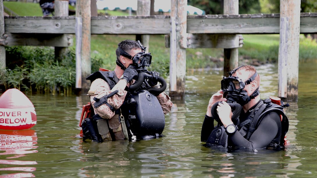 Gunnery Sgt. Zachary Burgart (left), project officer for amphibious reconnaissance equipment, and Master Sgt. Brad Colbert (right), project officer for small craft, MK25 closed-circuit underwater breathing apparatus in Spotsylvania, Virginia July 21, 2015. The system is a closed-circuit underwater breathing apparatus that allows its users to remain concealed in covert operations. 