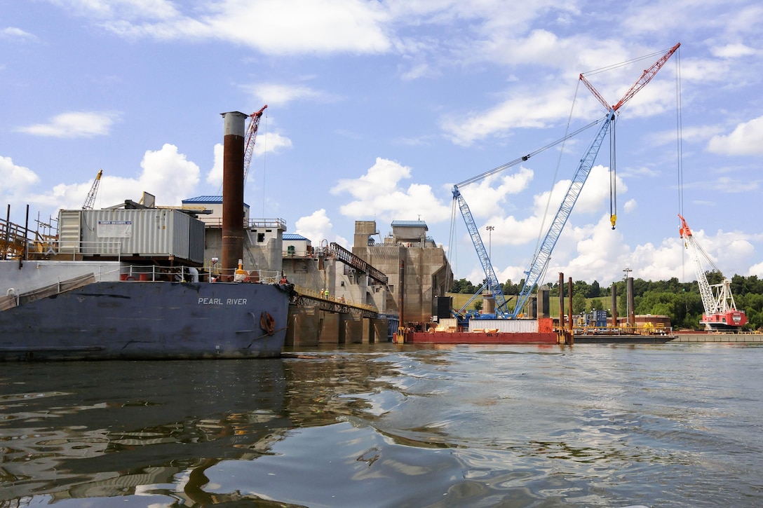 At the Olmsted Dam Project on the Ohio River,  the Pearl River provides maritime work platform and crane support. In the background workers and equipment prepare for the first ever barge traffic through the locks and the placement of the second tainter gate.