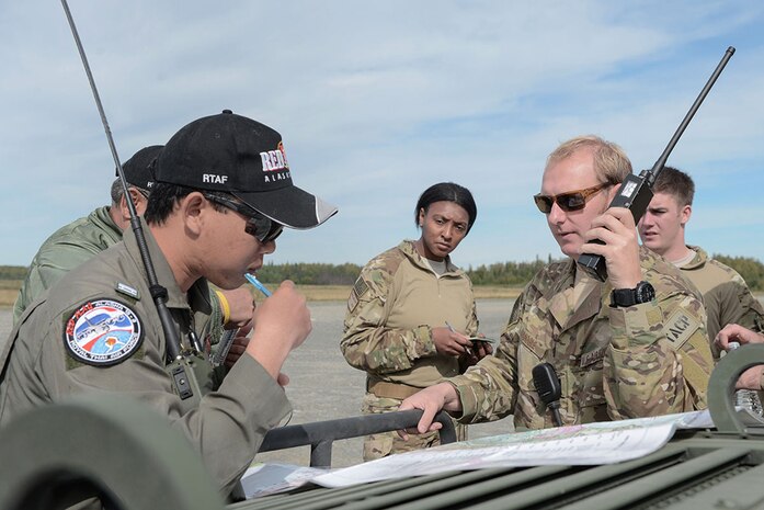 JOINT BASE ELMENDORF-RICHARDSON, Alaska (Aug. 24, 2015) - Flight Lieutenant Phongsakron Namjit, Royal Thai Air Force combat controller, and U.S. Air Force Capt. Michael Spanogle, 3rd Air Support Operations Squadron Air Mobility Liaison Officer, coordinate an airdrop during Red Flag Alaska 15-3. 