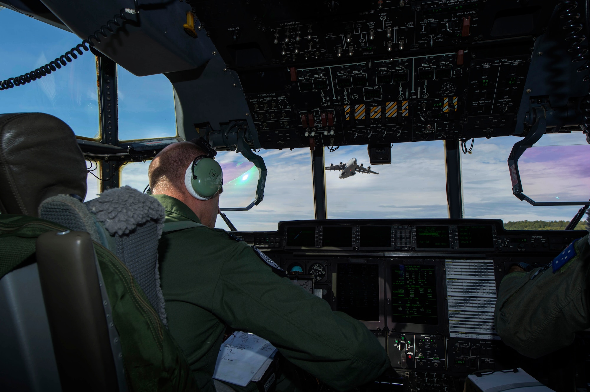 Royal Air Force Flight Lt. Graeme Hunt, a British C-130J Super Hercules pilot on exchange with the Royal Australian Air Force's No. 37 Squadron holds short of an intersecting runway while a C-17 Globemaster III performs a touch and go during Pacific Airlift Rally on Aug. 25, 2015, at Joint Base Elmendorf-Richardson, Alaska. Pacific Airlift Rally is a biennial, military airlift symposium sponsored by Pacific Air Forces for nations in the Indo-Asia-Pacific region. This year marks the 10th iteration of the PAR exercise series, which began in 1997. (U.S. Air Force photo by Staff Sgt. Sheila deVera/Released)